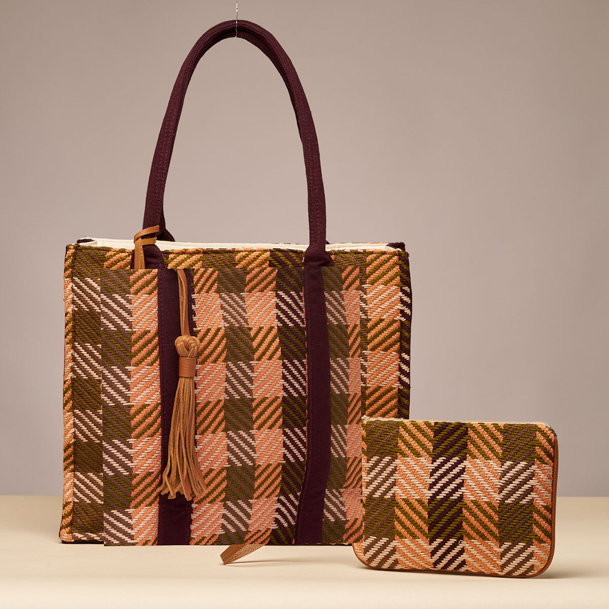 Hand woven artisan Teresa Wallet and Irma Tote are displayed together. Both are in Moss Weave, an orange and olive green plaid.