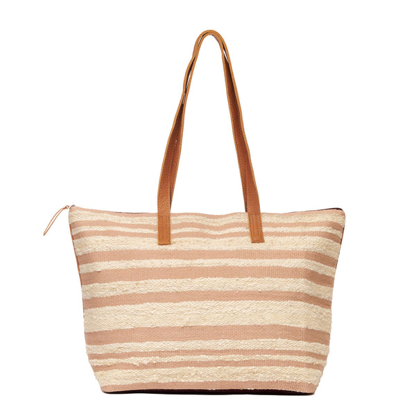 Hand woven artisan Estella Tote in Snow pattern. It has a frontal view of the bag with horizontal beige and light pink stripes. It has a leather handle and a leather zipper pull at the left.