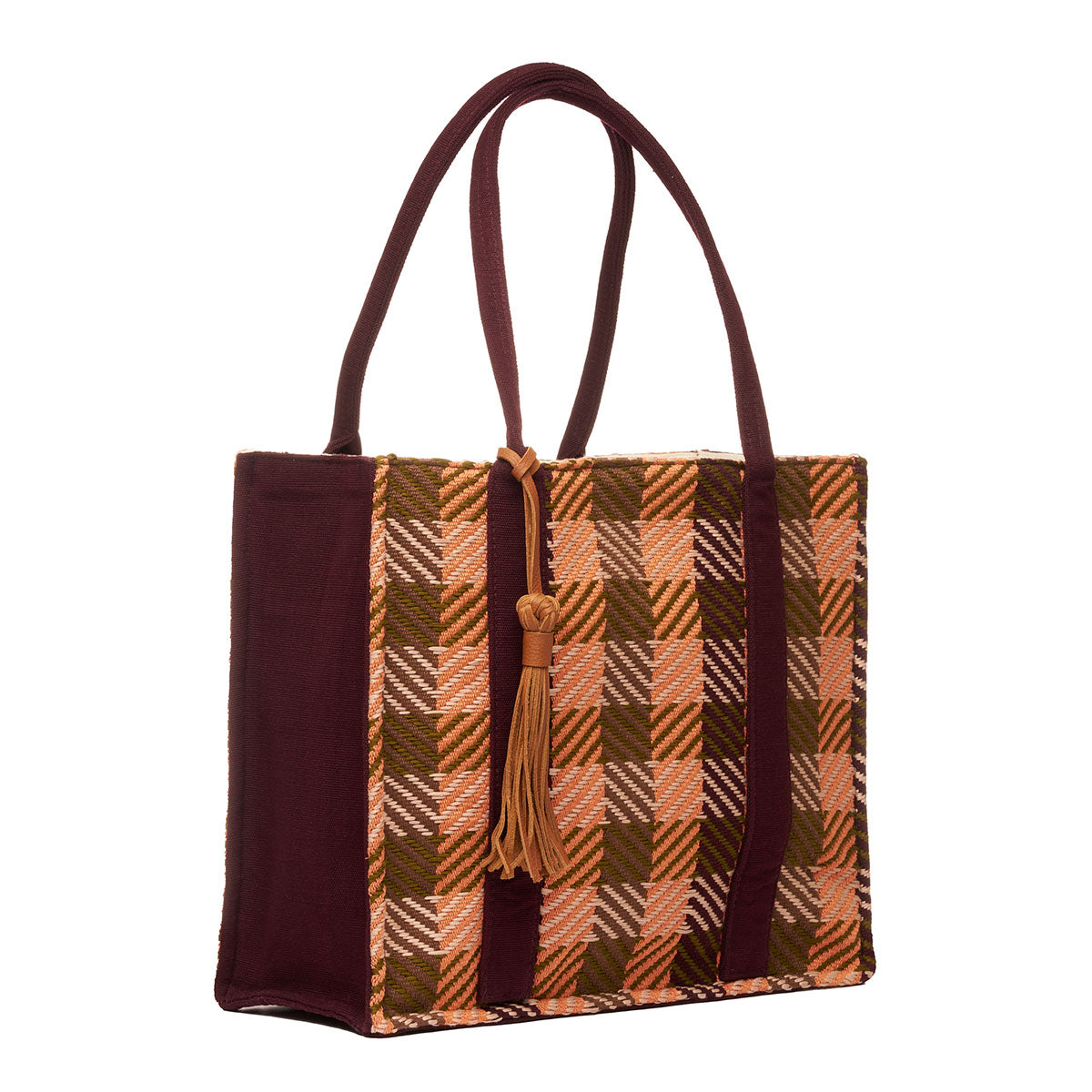 Hand woven artisan Irma Tote in Moss Weave pattern shown at an angle. The tote has a sharp rectangular shape. The sides have a dark brown solid color. The moss weave is a grid plaid pattern in olive green and orange colors. It has a leather tassel attached to the handles.