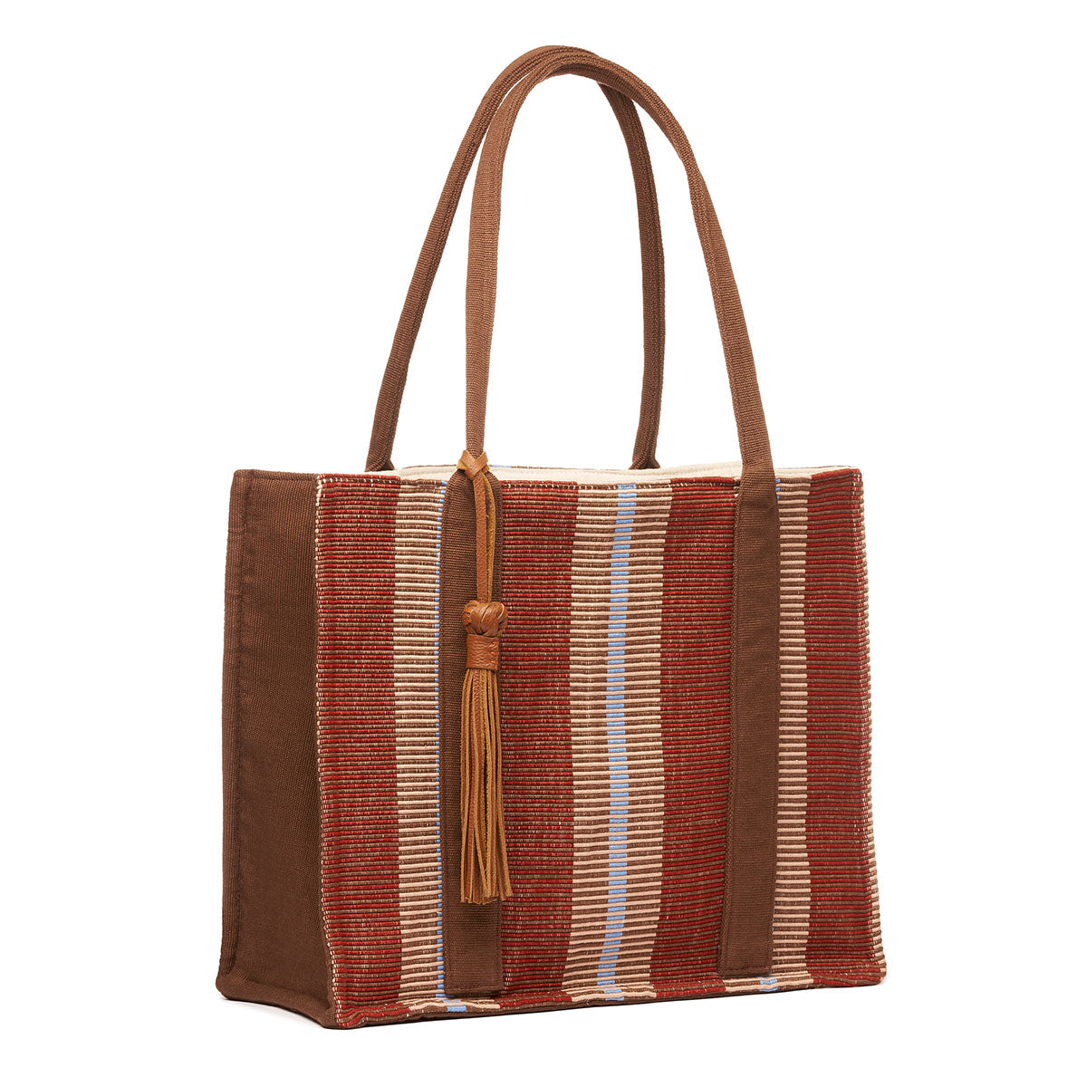 Hand woven artisan Irma Tote in Chestnut color. The bag is shown at an angle. It has a rectangular shape, burgundy and tan vertical stripes, and a leather tassel attached to the handles.