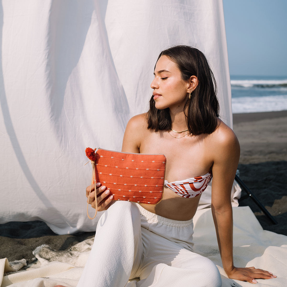 A model holds the Mini Lily Wristlet in Desert Sands.