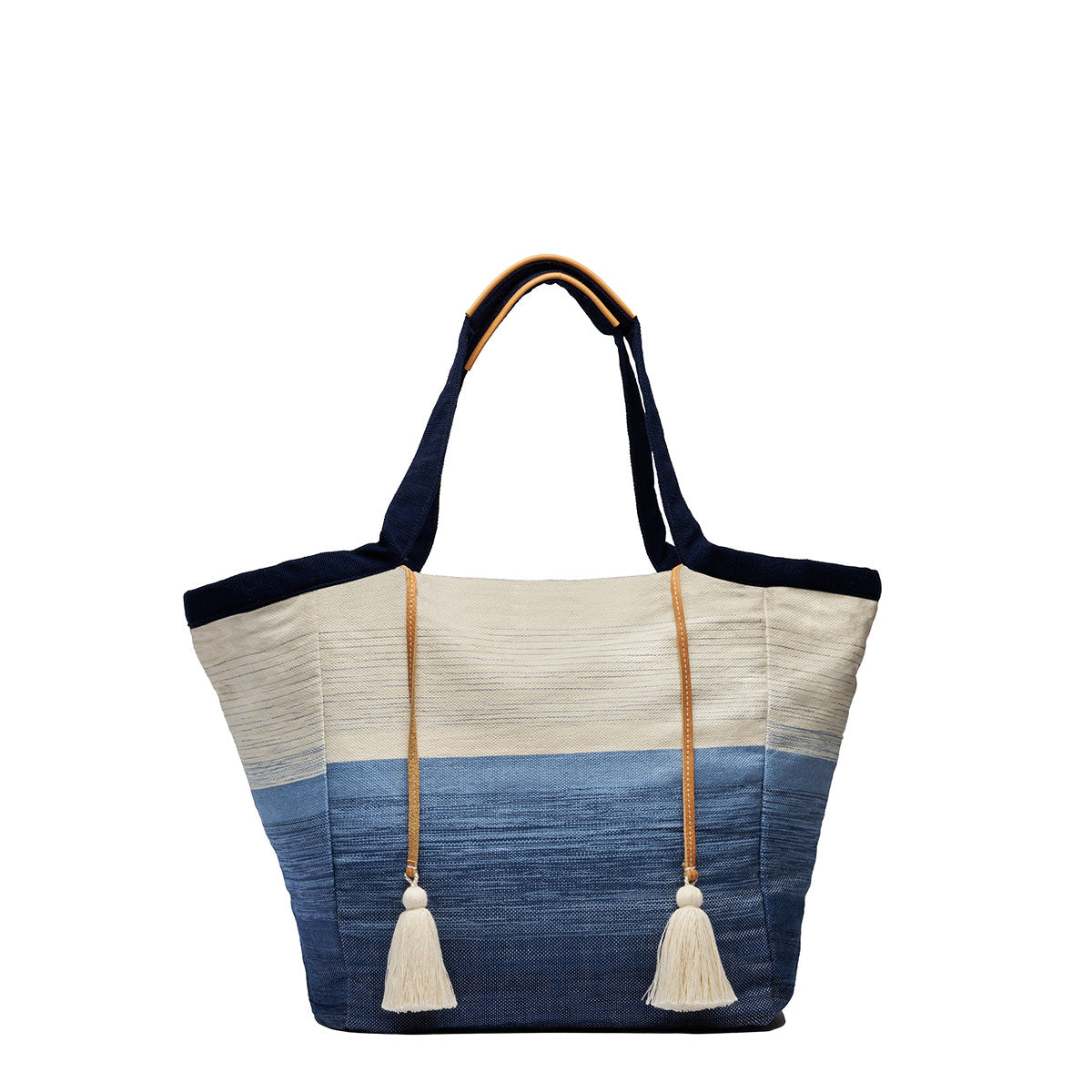 Rosa Tote in Ocean Breeze. It has a two-toned fabric, white at the top and blue at the bottom. It has dark fabric handles with leather detailing and two white yarn tassels.