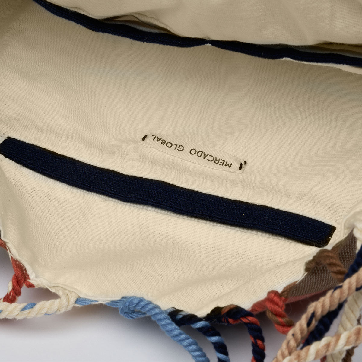 Interior view of the Apolonia Tote in Blue Canyon. It has three interior pockets and beige lining with a dark blue hem.