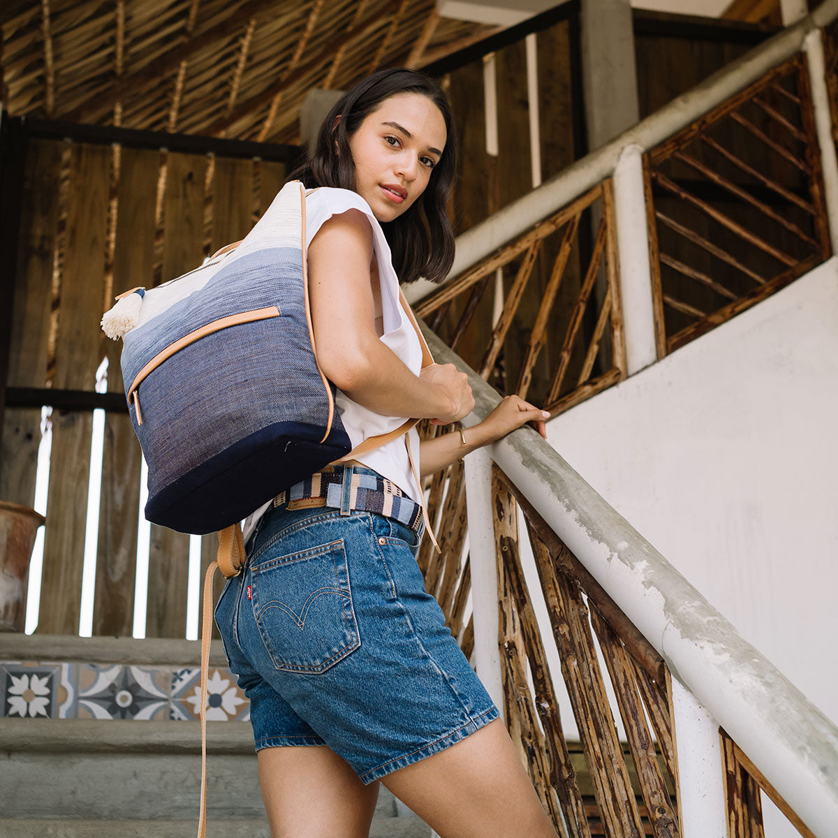 A model wears the Celeste Belt in Skyscape and the Lorena Backpack over her shoulder.