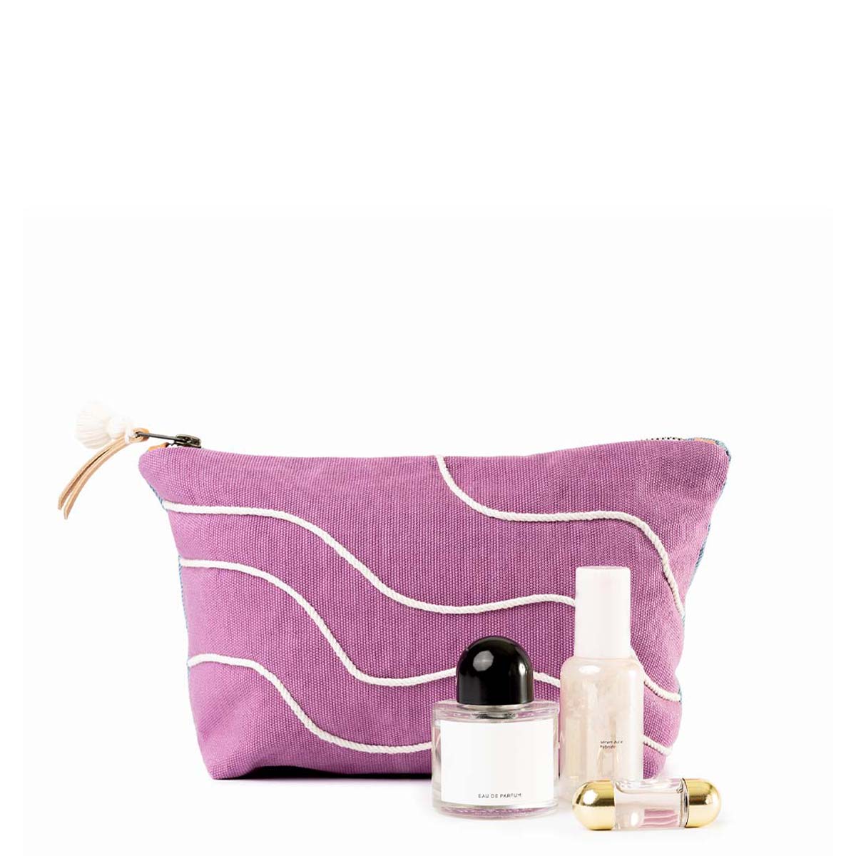 The front of the Cristina Cosmetic Pouch in Cosmic Waves pattern. It has a magenta solid background with thin wavy white stripes.  It is modeled with a few cosmetic bottles to the side. 