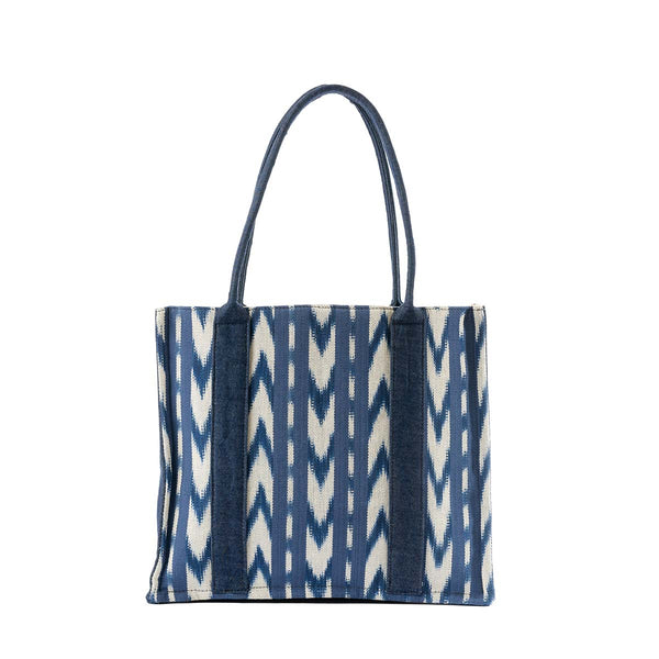 The front of the hand woven artisan Irma Tote in Atitlán Hills pattern. It has vertical and chevron dark blue and white stripes.