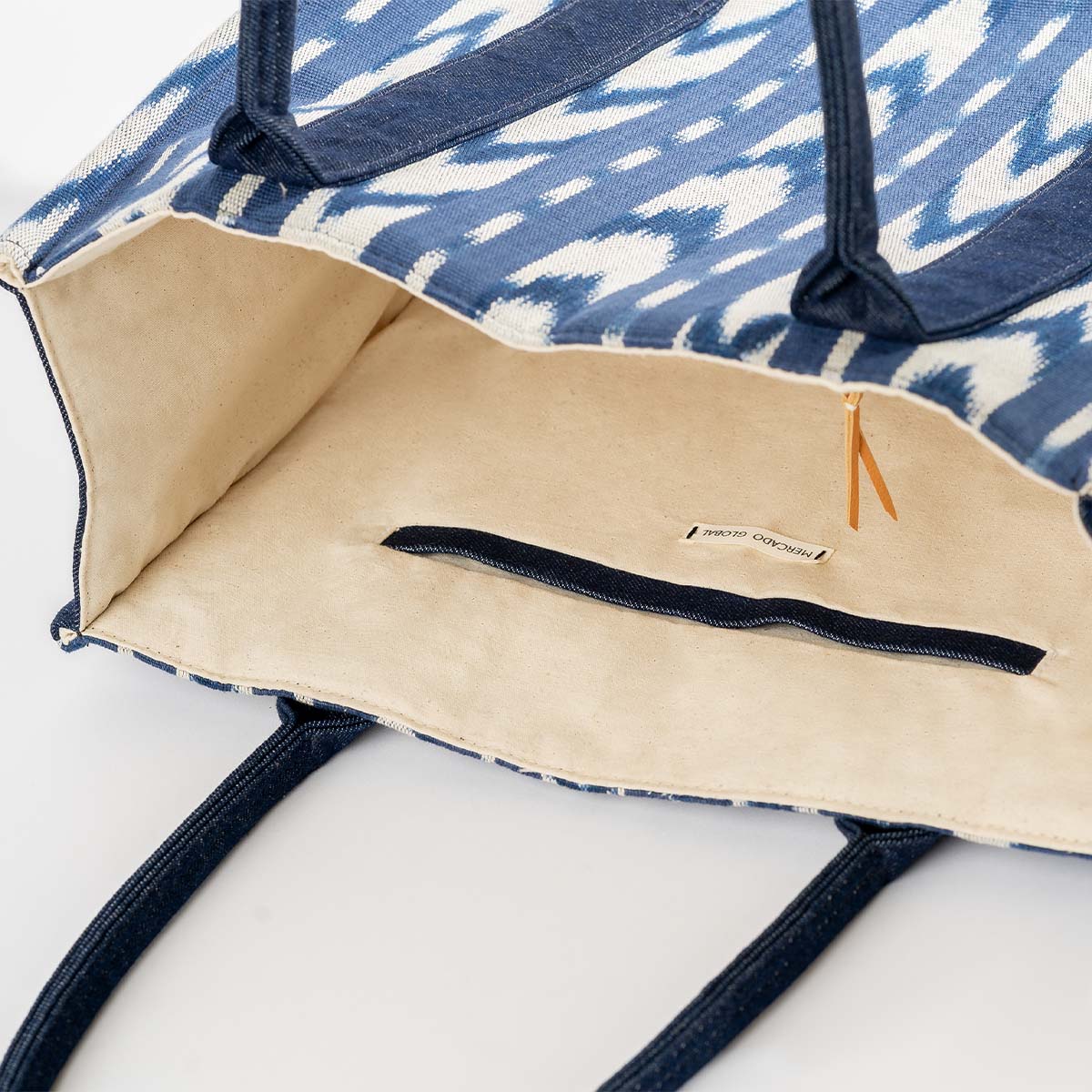 The interior of the hand woven artisan Irma Tote in Atitlán Hills. The interior has a solid beige color and a dark blue hem.