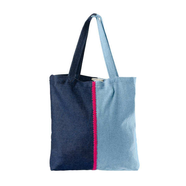 Front of the hand woven artisan Silvia Tote in Denim Divide pattern. One side has a light wash denim stitched with red thick thread to a dark wash denim.